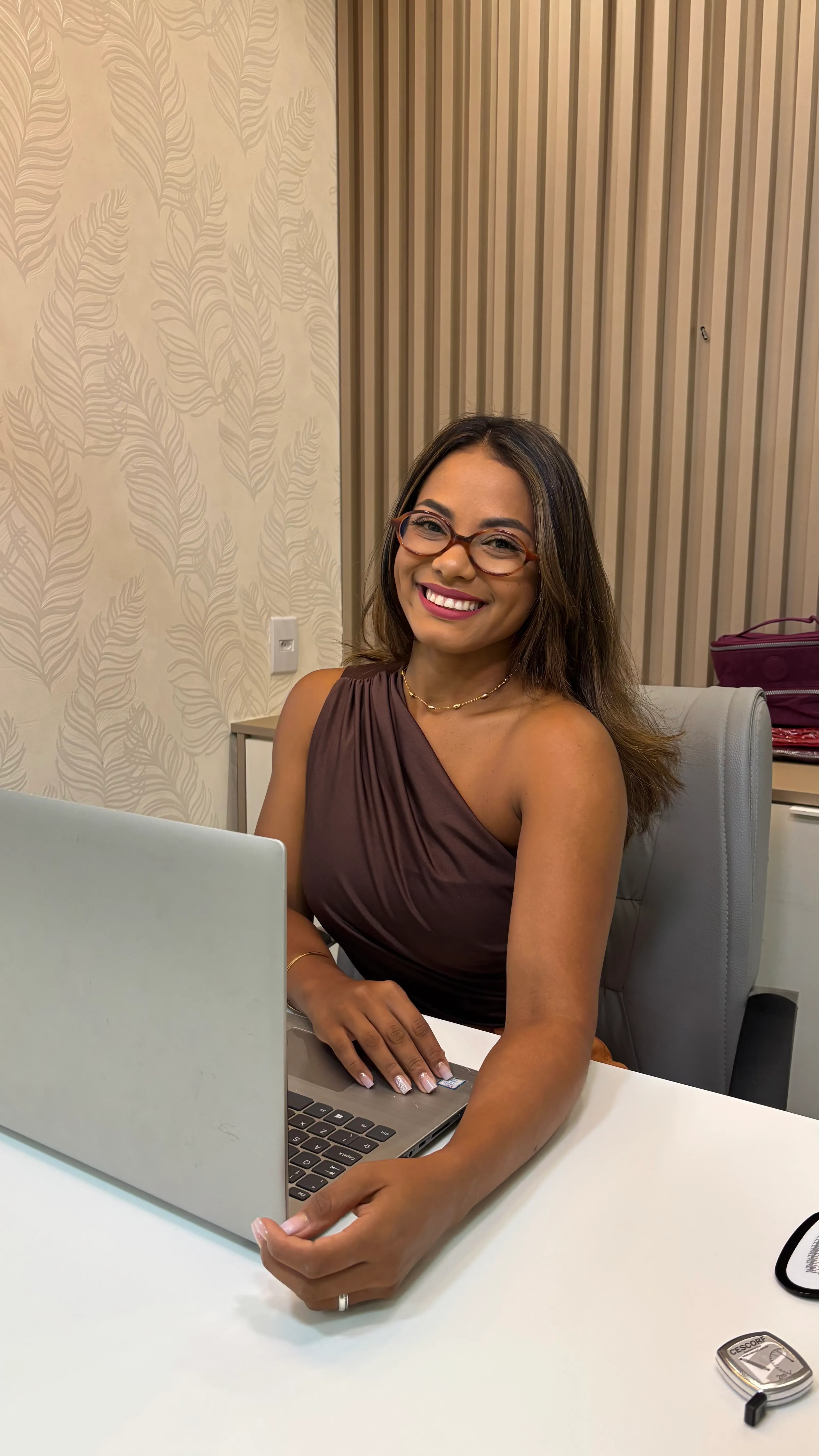 Amanda Sena atendendo em seu consultório, ao computador